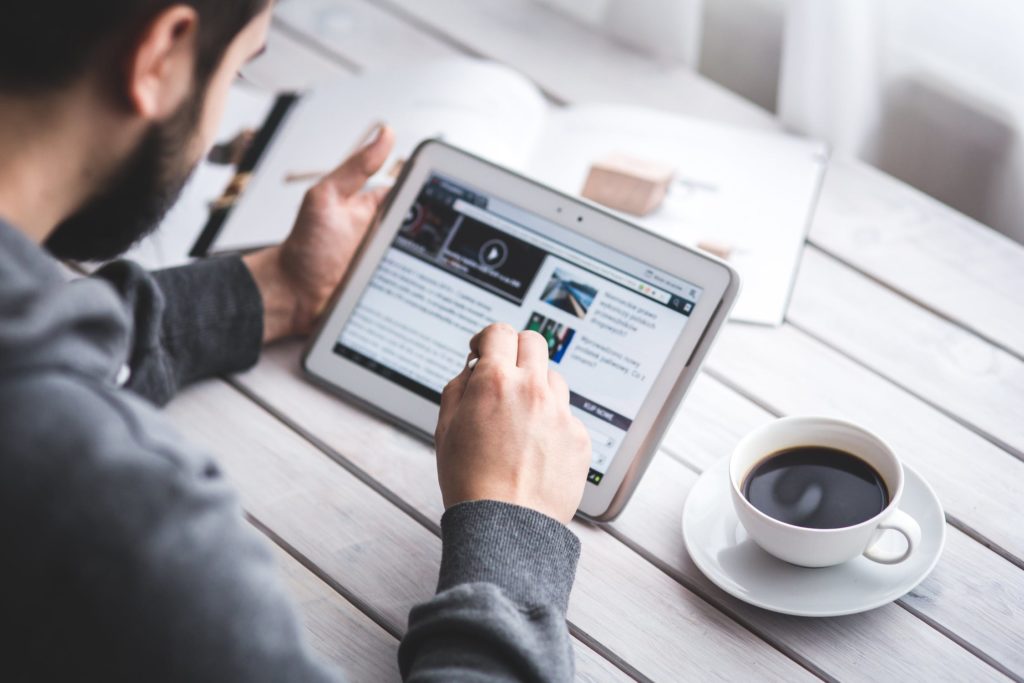 Man reading on ipad newsletter